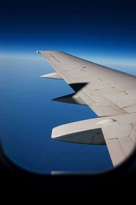 地平线上的飞机机翼，透过窗户拍摄，拷贝空间