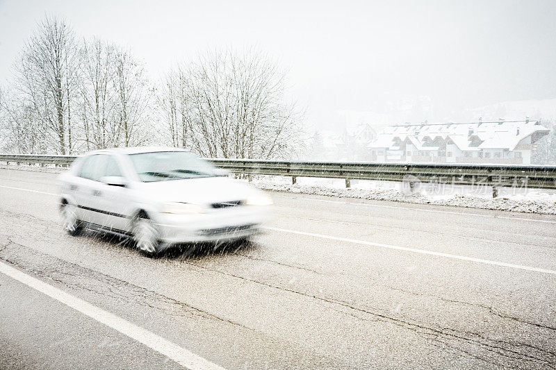 在下雪时快速行驶的汽车