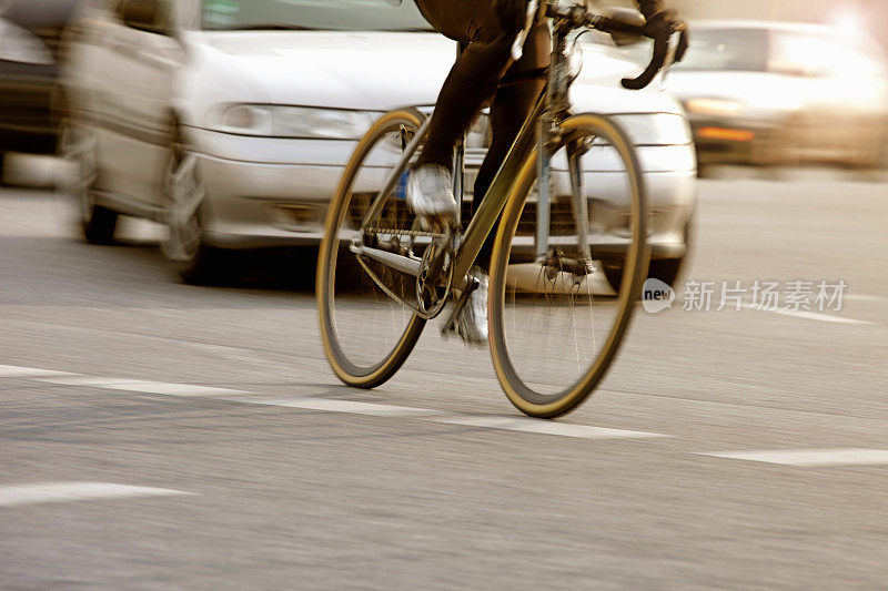 骑自行车上下班的人通过城市的街道，汽车，交通，危险