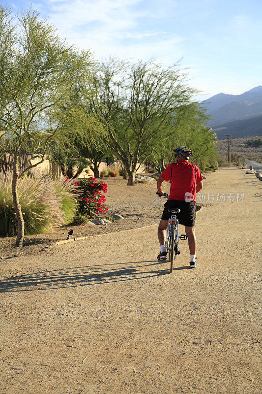 骑自行车经过一个干旱的沙漠花园