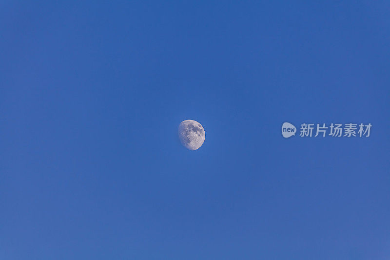 月亮在白天的蓝色天空