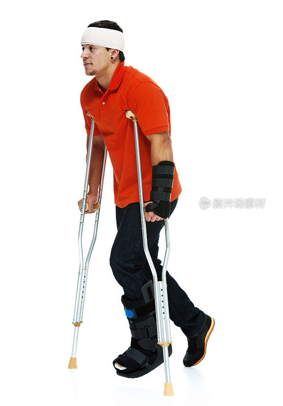受伤男子拄着拐杖走路的侧面图