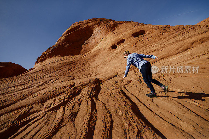 青少年攀登纪念碑谷的砂岩斜坡