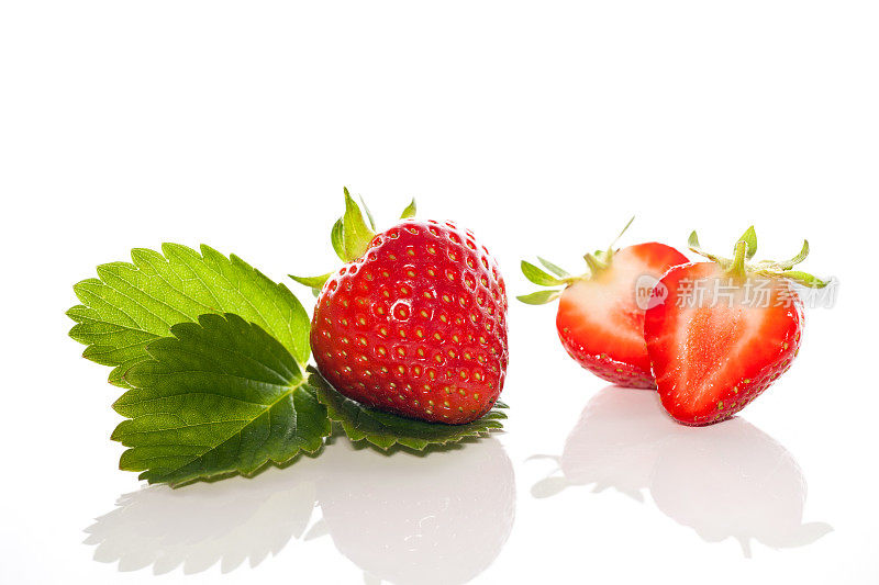 整个草莓在白色的背景上切成两半
