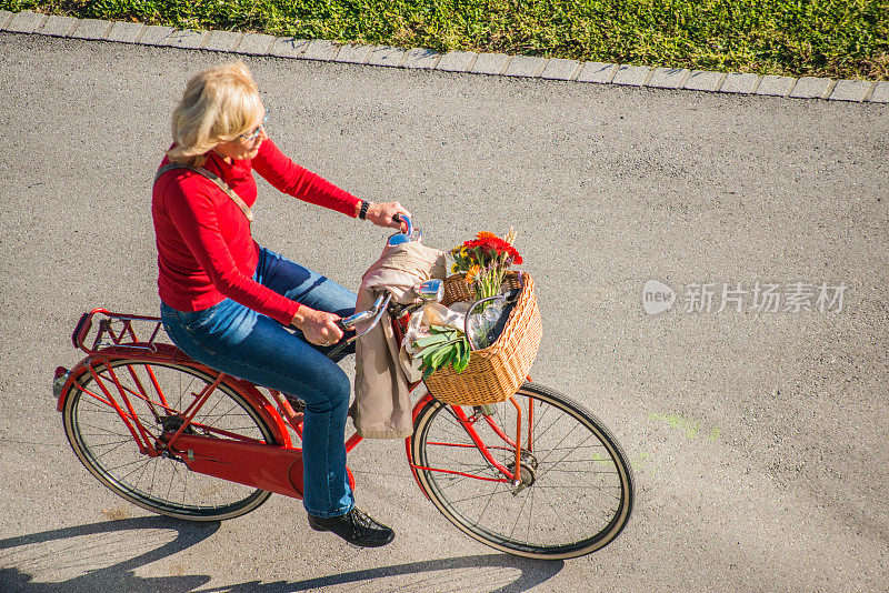 在城市里骑自行车的老妇人