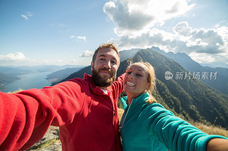 徒步旅行者到达山顶并自拍