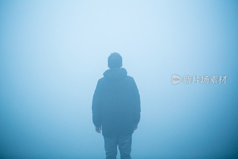 年轻人站在雾中