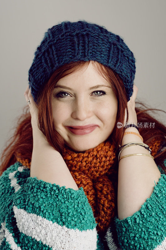 红头发的女人穿着冬装微笑着看着镜头