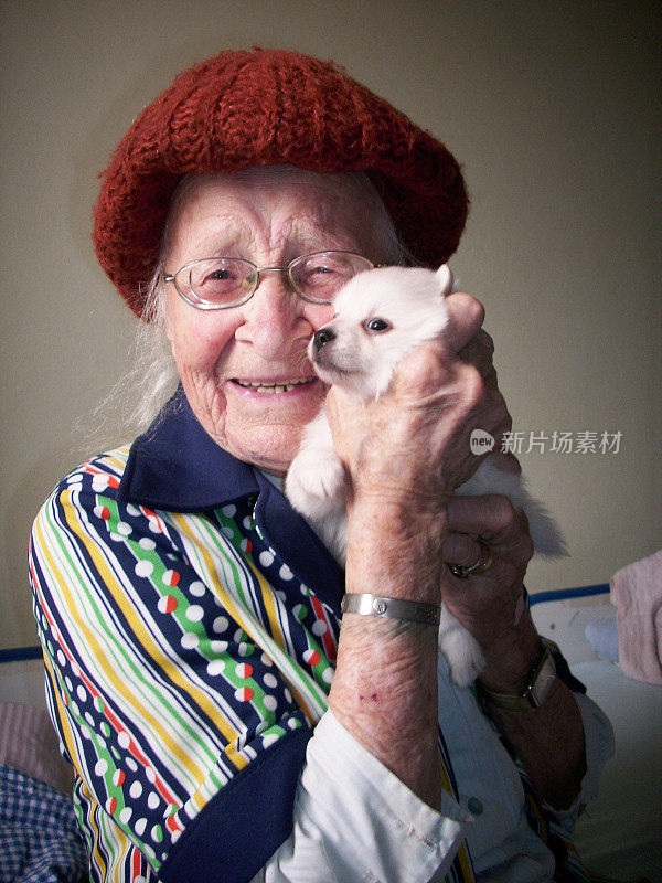 一个快乐的老妇人抱着一只小狗