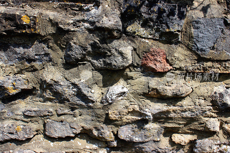 图像显示一个质朴的鹅卵石墙，与尖尖的不规则石头