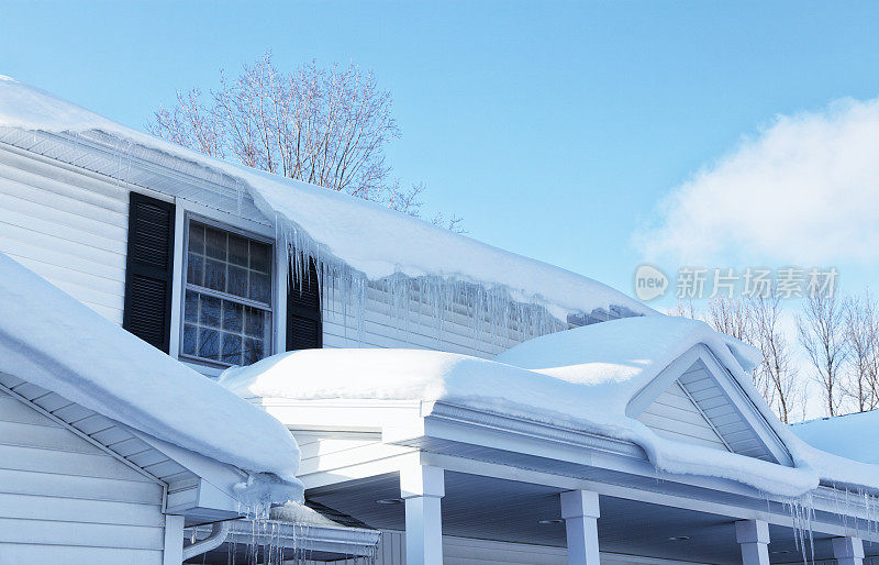 住宅屋顶边缘融化的雪和冰柱