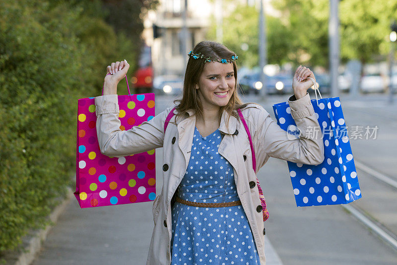 漂亮快乐的女孩拿着购物袋，尽情享受购物的乐趣