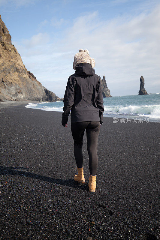 探险家走在冰岛的黑沙滩上
