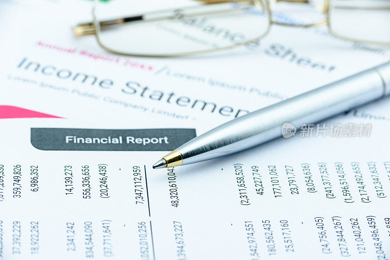 蓝色圆珠笔在公司季度财务报告上。