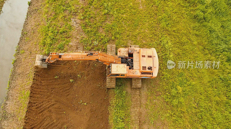 挖掘机在田里挖沟。航拍视频