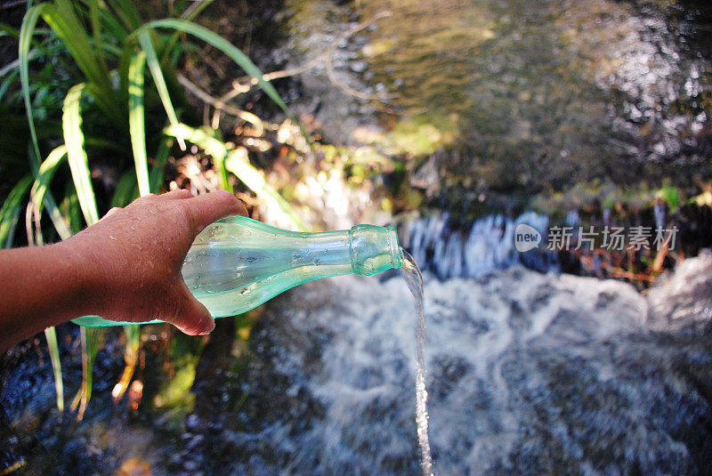 淡水水概念;玻璃水瓶与河流背景