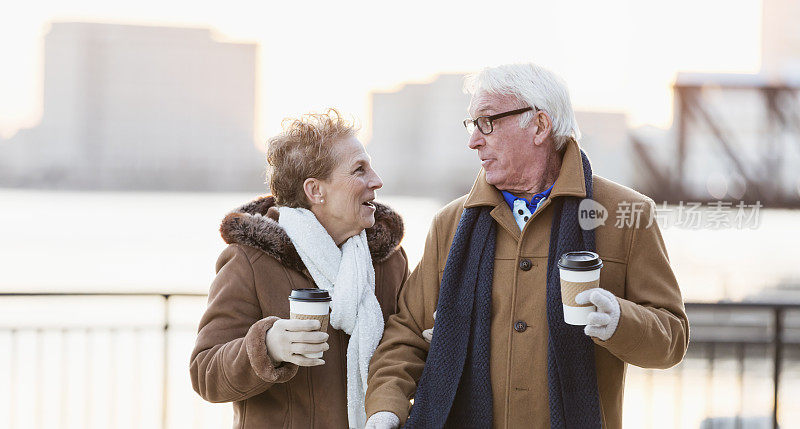 老夫妇在城市海滨边喝咖啡边聊天