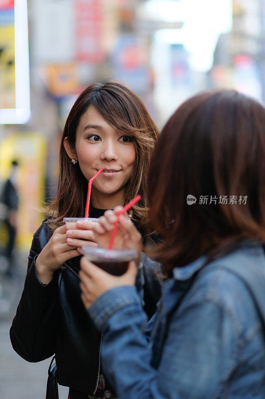 两个女人在街上喝咖啡