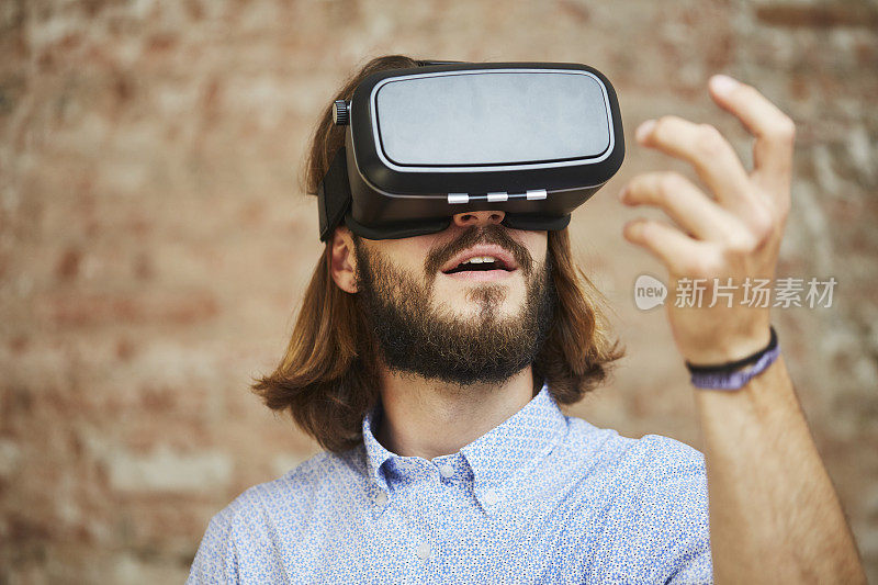 惊叹于VR布景，人用虚拟现实模拟器头戴。