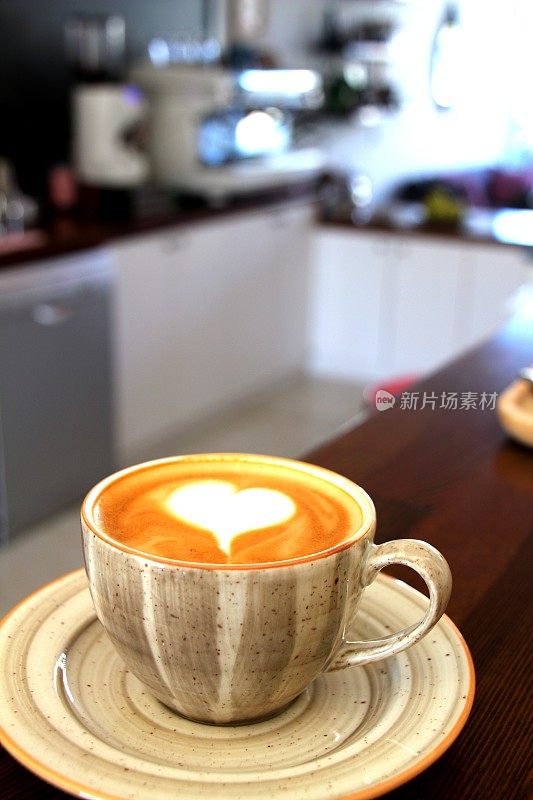 心形咖啡杯和现代咖啡机的背景