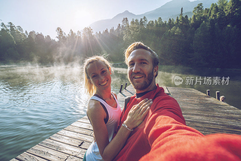 年轻夫妇的自拍照在湖码头在早晨的雾，瑞士