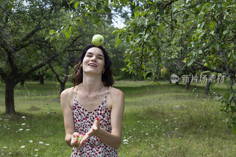 快乐的女人耍绿苹果。