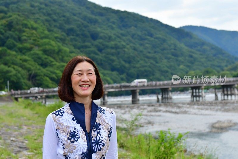 行走在京都岚山河畔的日本妇女