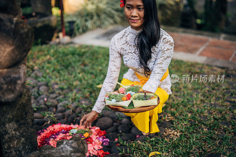 亚洲妇女，穿着传统的巴厘服装和鲜花