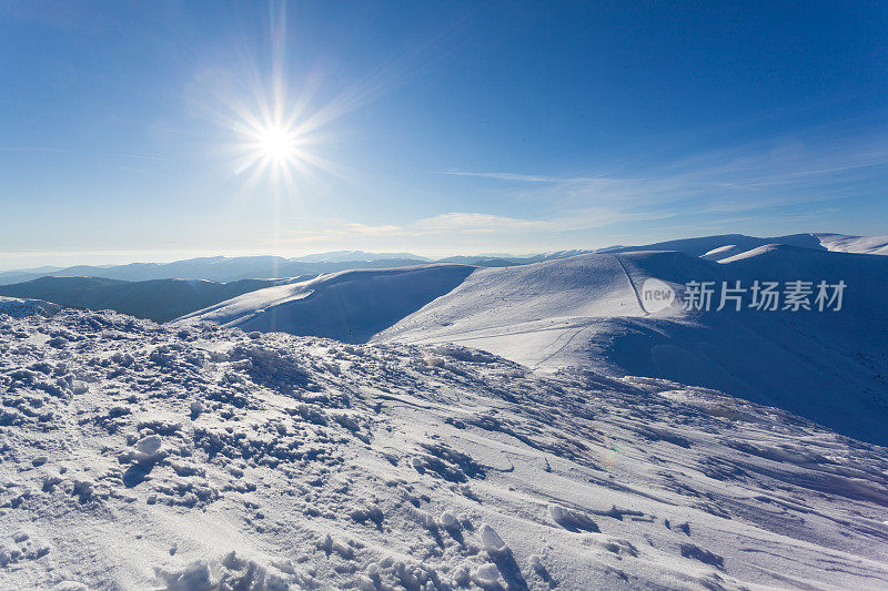 美丽的冬季全景与新鲜的粉末雪。风景与云杉，蓝天与阳光和高喀尔巴阡山脉的背景