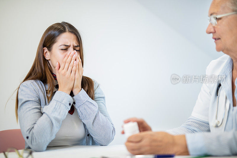 年轻女子与感冒和流感访问她的医生持有一种药。