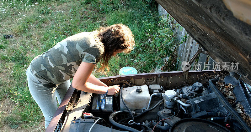 一个女人在修她的旧车