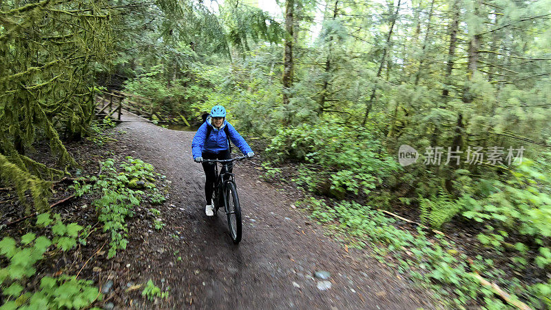 女性山地车沿着森林小径骑电动自行车