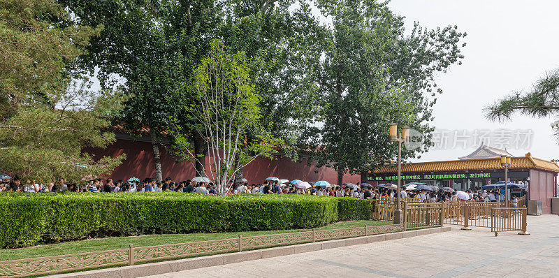 在进入天安门广场和紫禁城的安全检查站前，一大群游客排着长队