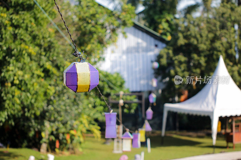 现代的灯笼挂在穿过节日庭院的缆线上
