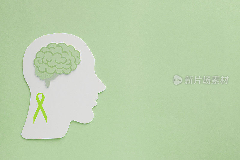 绿色背景的脑纸剪纸，心理健康理念，世界心理卫生日