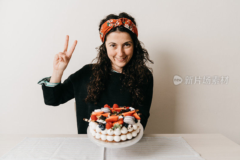 一个女人正在家里用奶油馅饼庆祝她的生日