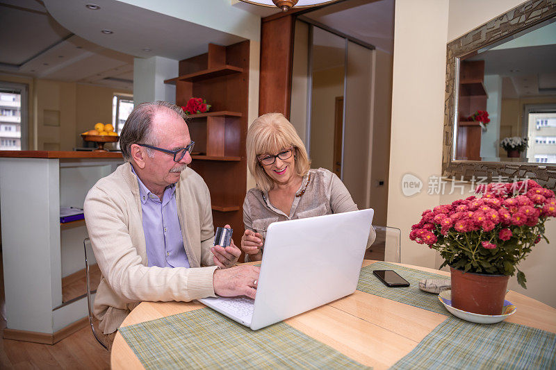 一对老年夫妇在家里一起享受网上购物计划。