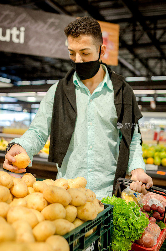 一个年轻人戴着口罩在杂货店购物