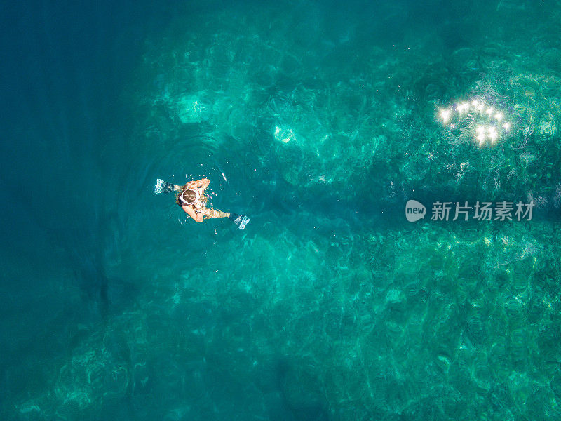 女人浮潜在惊人的珊瑚礁之上