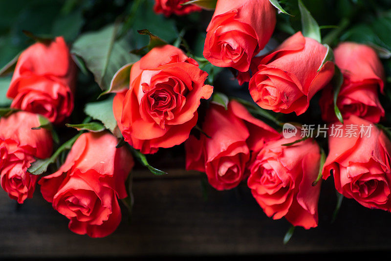红玫瑰花束放在一张木桌上
