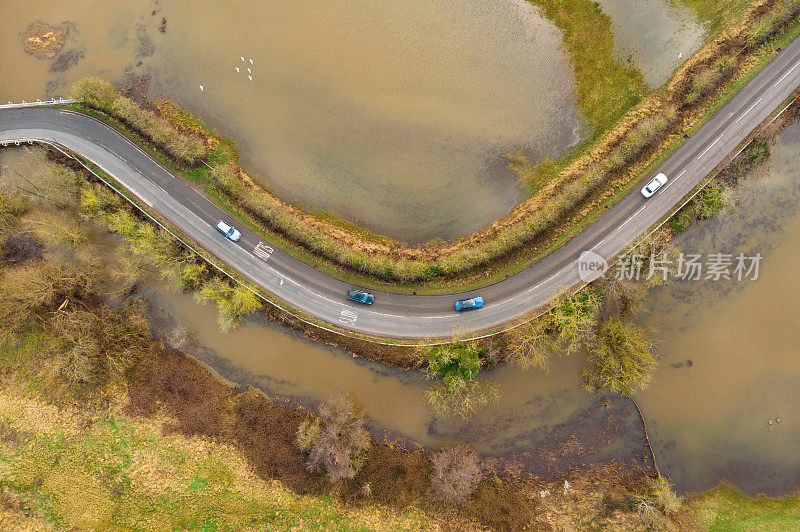 道路经过洪水泛滥的田野，鸟瞰风景