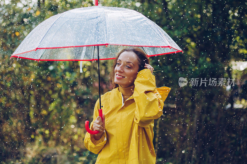 快乐的女人在雨中行走