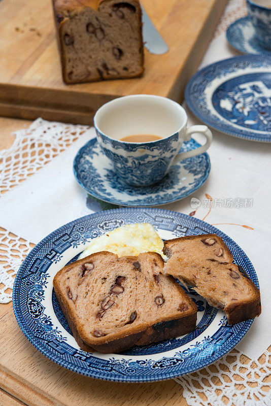 乡村杂粮和豆类工匠面包片和煎蛋在蓝柳盘早餐桌上