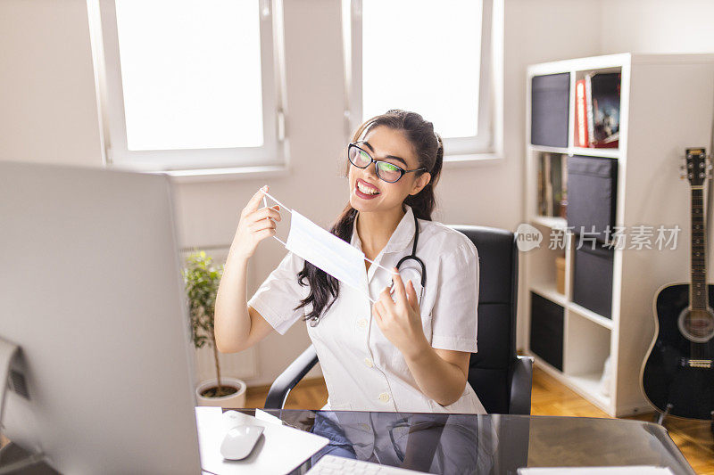在冠状病毒大流行期间，微笑的女医生在数字平板电脑上与患者视频通话