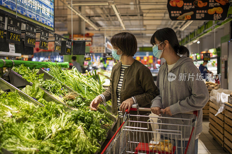 母女俩在超市买菜。