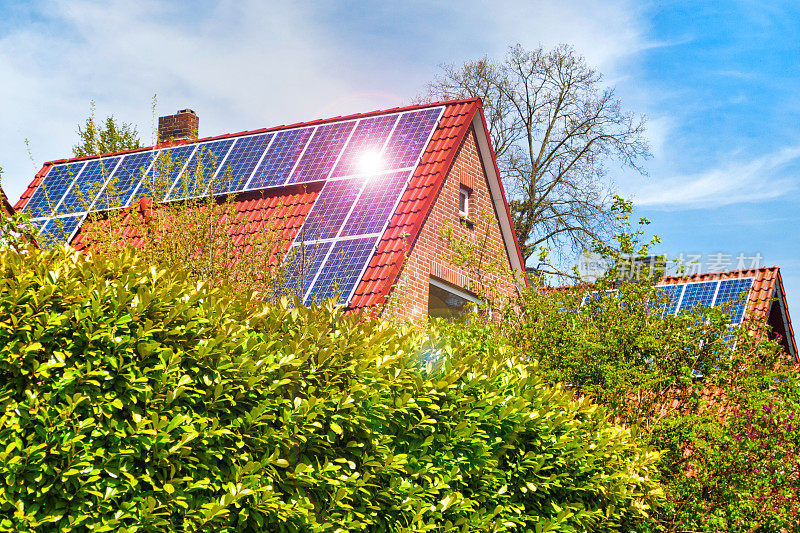 瓦片屋顶上装有太阳能电池板的旧式家庭住宅变得现代化了