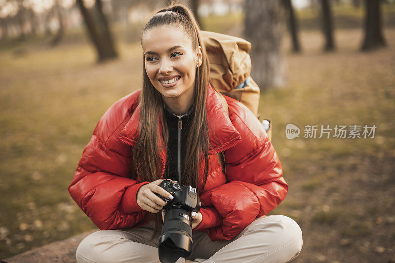 一名年轻女子在山里徒步旅行时拍照