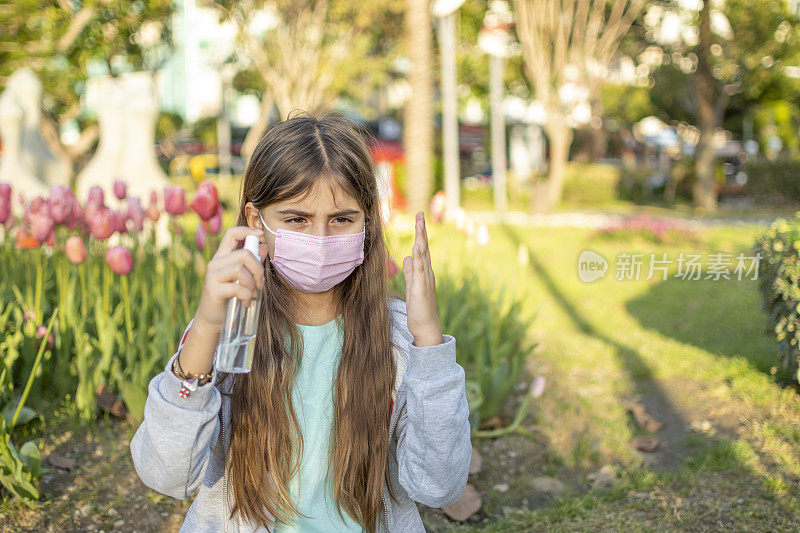 一个女孩从塑料瓶中倒出消毒冠状病毒的消毒剂