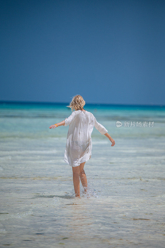 沙滩上穿着白衬衫的女人