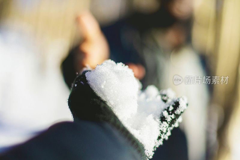 冬天伸出手拿着雪的女性